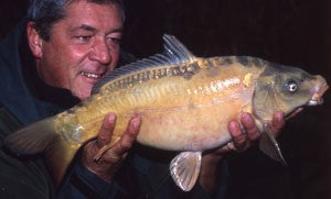 Ken holding up a shiny fish.