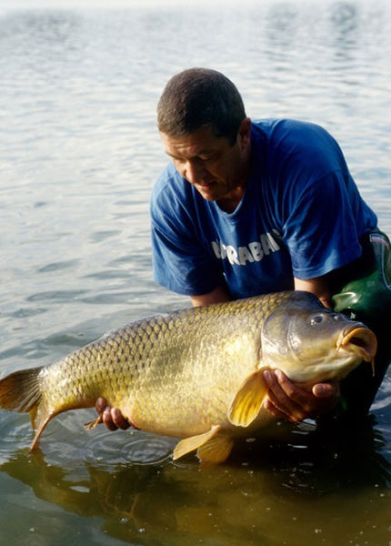 Ken's holding his catch, a large carp.