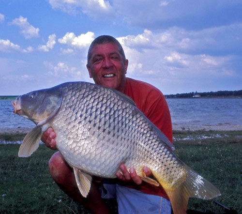Ken holding a large shiny carp weighing 28lb.