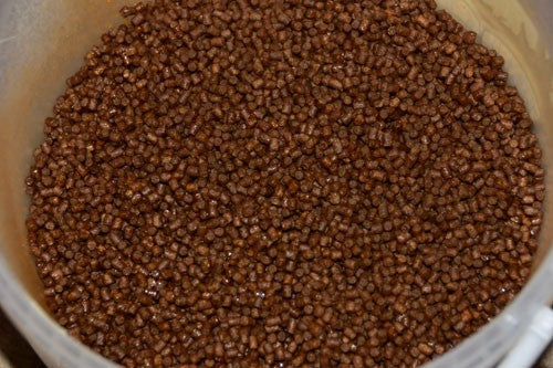Glossy brown pellets in a large mixing bowel.
