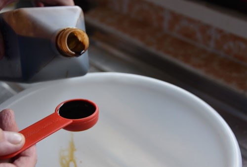 Photo of white plastic bowl being filled with liquid attractor