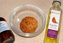 Image of a round yellow boilie with a bottle of oil