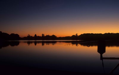 Image of a lake at dusk with the sun setting