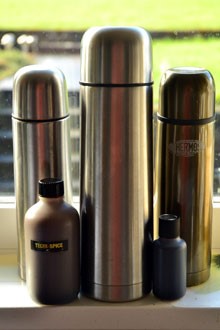 Image of thermos flasks and liquid bait stood in front