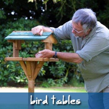 Image of Bill Oddie filling up a bird table.