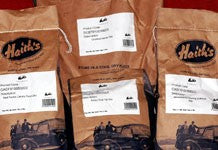 Image of a row of four bird food baits in branded bags