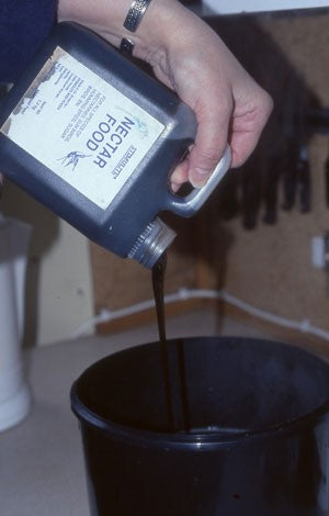 Image of a black bucket having liquor attractor being poured in to it
