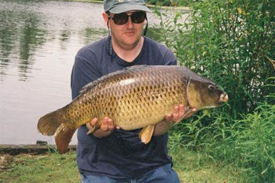 Image of a fisherman holding a large carp