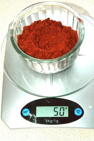 Photo of 50g of Robin Red in a glass container on weighing scales