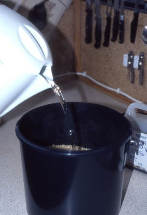 Image of a black bucket having boiling water added to it