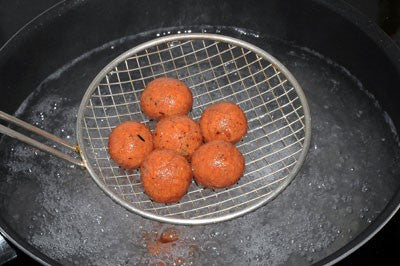 Photo of finished boilies being drained above a pan of boiling water in a colandern