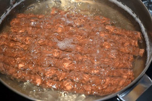 Photogragh of sausage like bait in pan of boiling water