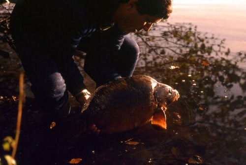 Photo of Ken Townley at dusk holding a carp