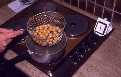 Photo of a colander full of boilies on a cooker top