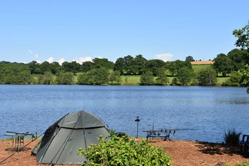 Tent and fishing equipment round lake.