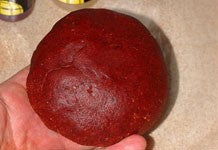 Image of red bird food base mix being shaped into a ball