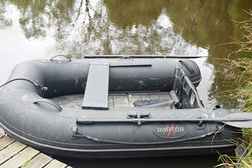 Black raptor boat on the water.