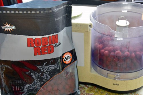 Bag of Robin Red boilies next to a mixer filled with red boilies.