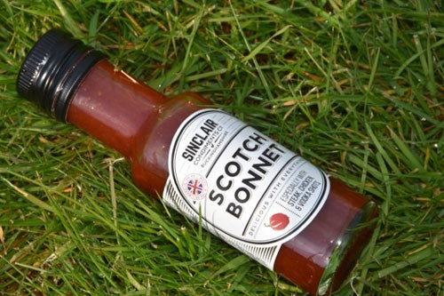 Bottle of Scotch Bonnet filled with dark red sauce.