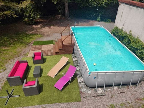 Large outdoor swimming pool next to relaxing sun lounger space.