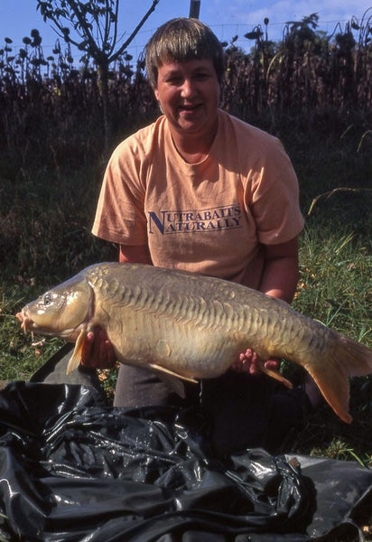 Tat holding a large carp she caught.