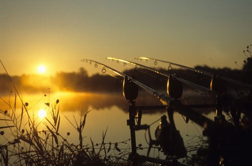 Vibrant sunset over a quiet fishing lake.