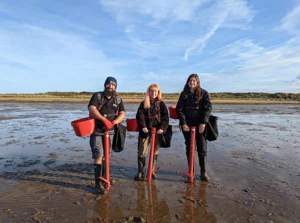 Group of three people starting to plant seagrass in the river Humber