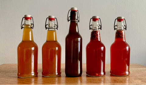 Bottles of kombucha on a table during the second fermentation.
