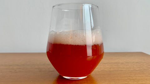 Glass of hibiscus-flavoured kombucha.