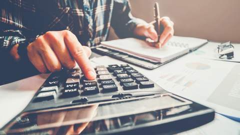 businessman working in office on desk using calculator and pen