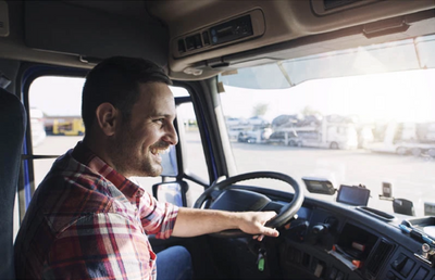 happy man in plaid shirt driving truck