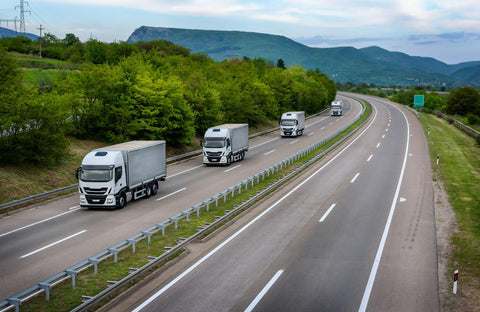 Four White trucks in line on a country highway
