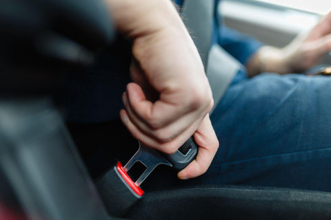 Men's hand fastens the seat belt of the car