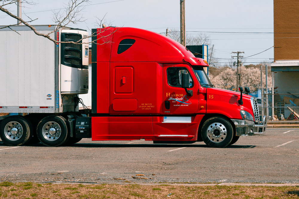 red and white truck on road during the daytime