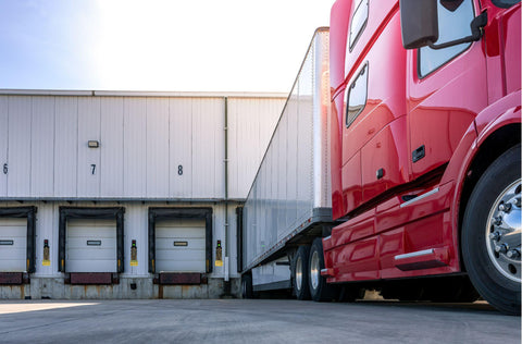 Red modern semi truck parked at the docks