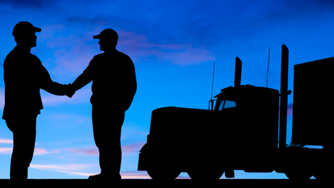 Silhouette of two truck drivers shaking hands