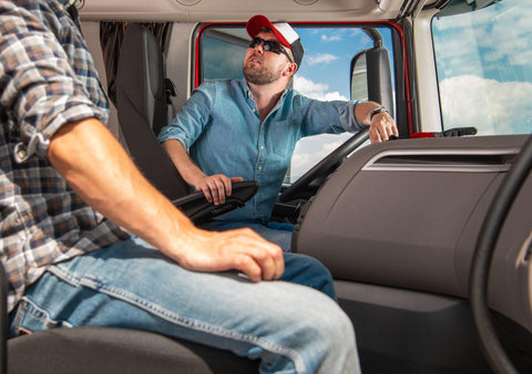 Two male truckers inspecting interior semi cabin