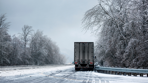 Winter forest with snowy road. Truck move on slippery road