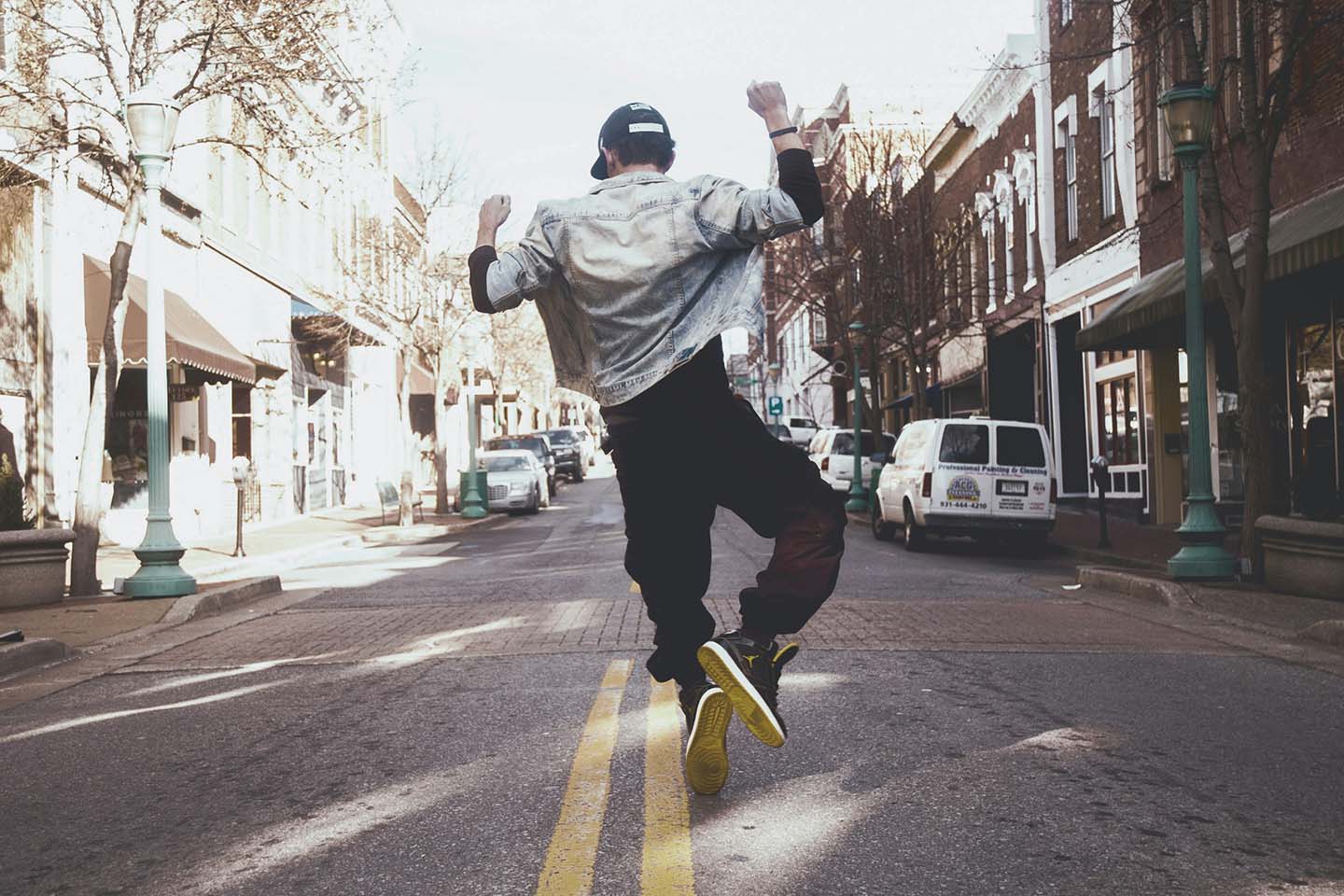 Man jumping with joy in the middle of a street