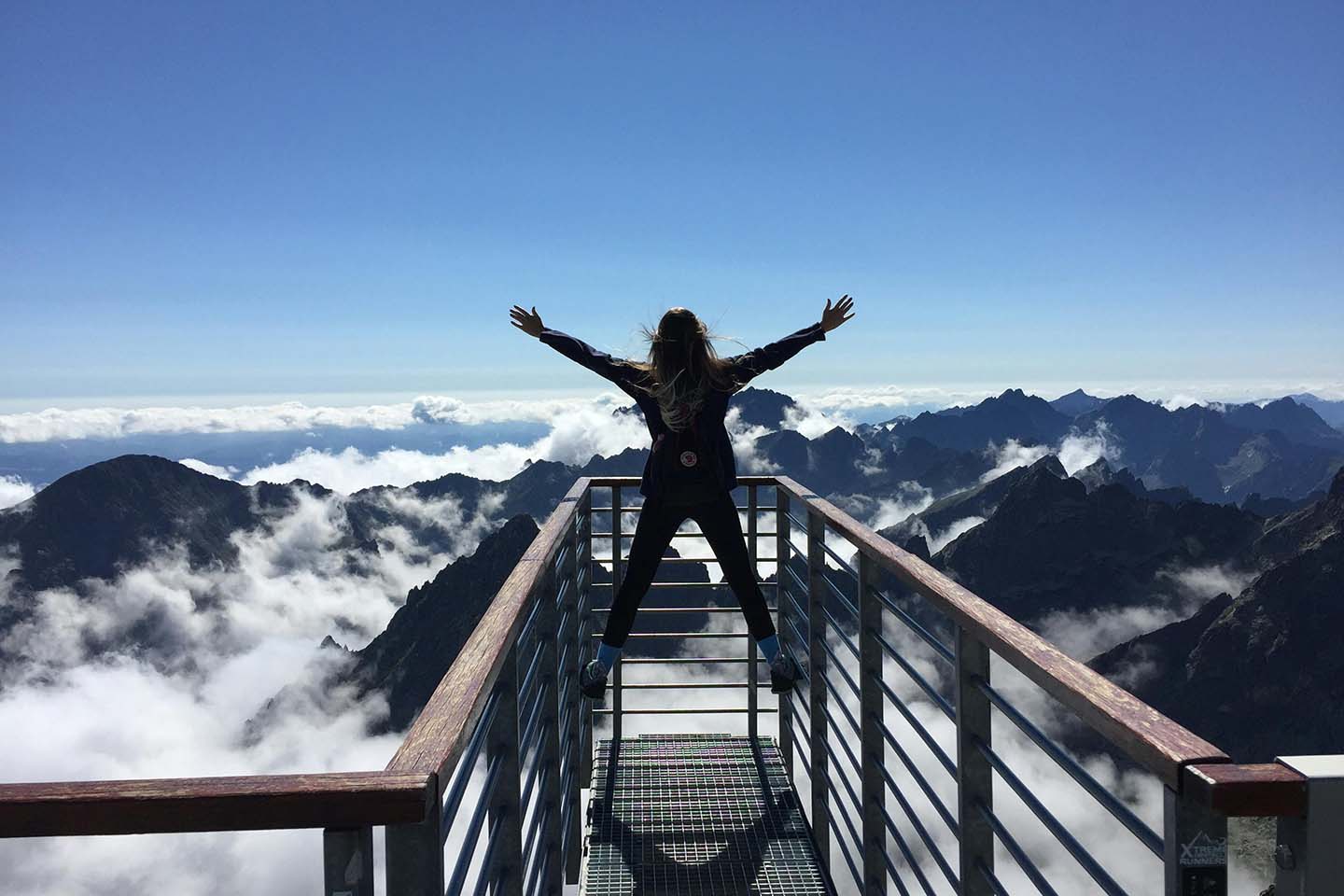 Woman on top of a mountain with outstretched arms