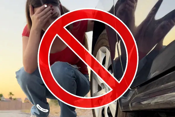 Person crouching by car tire with a red prohibition symbol.