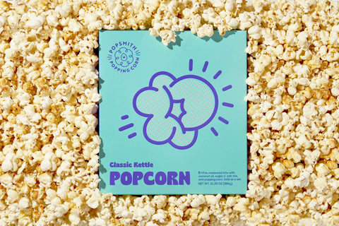 A box of Popsmith's Classic Ketlte Popcorn surrounded by kettle corn