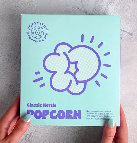 Woman shows off box of classic kettle popcorn