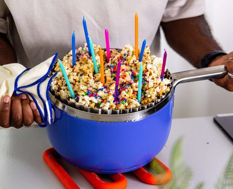 Man holds Popper filled with birthday cake popcorn and candles