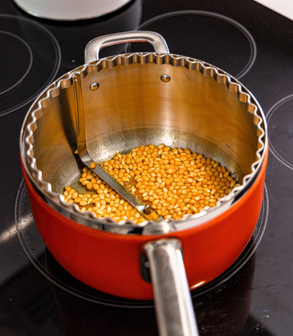 Orange Popsmith Popcorn Popper with kernels inside