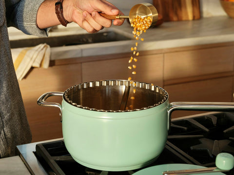 Person pours kernels into a mint Popper