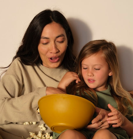 Mom and daughter stare at a bowl of popcorn
