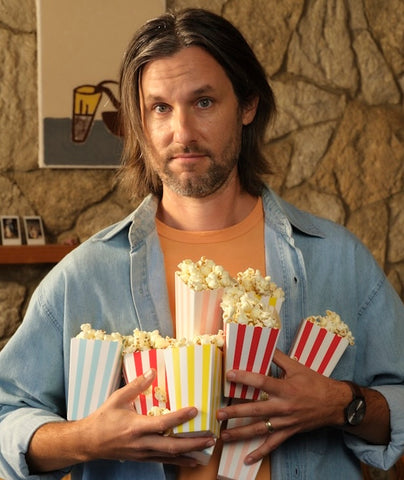 Man holds up several buckets of popcorn