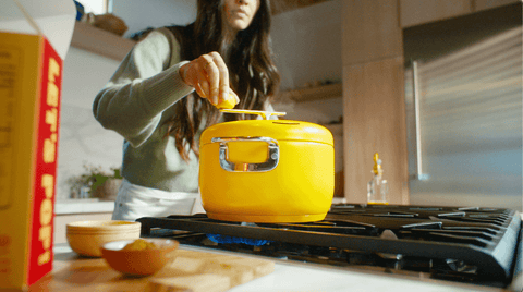 Woman turns the crank of a yellow popcorn popper