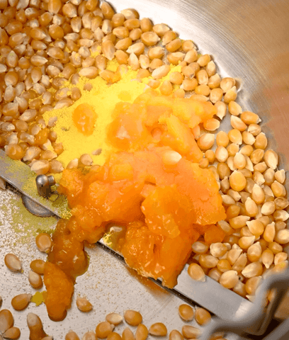 coconut oil mixed in with kernels in a Popsmith Popper